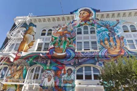 Um mural colorido e em grande escala cobre a lateral do Edifício das Mulheres no 教区 de São Francisco.