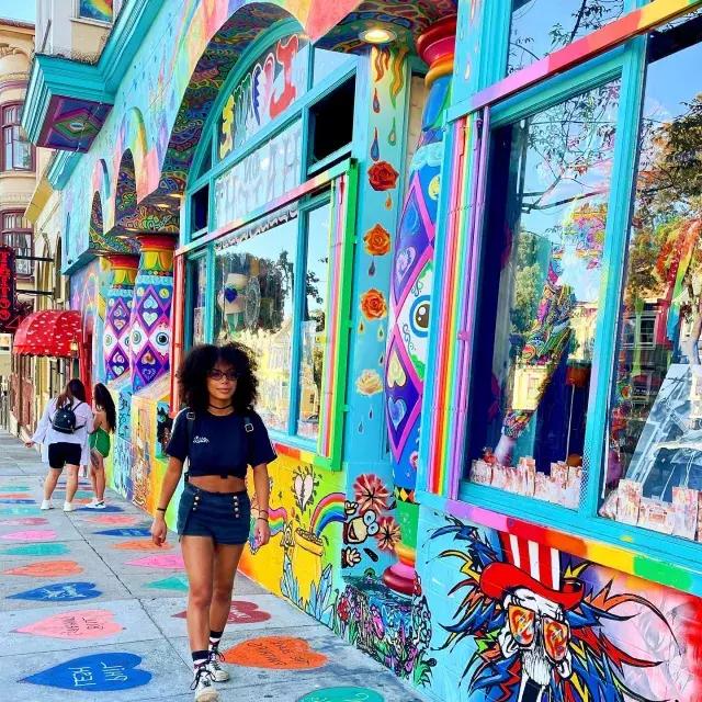 一个女人沿着海特街走，背景是一幅色彩鲜艳的壁画。.